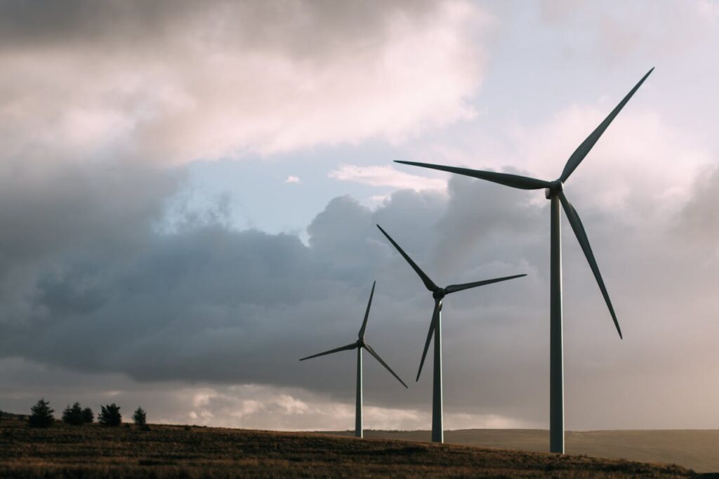 Wind turbines generating renewable energy under a dramatic cloudy sky.