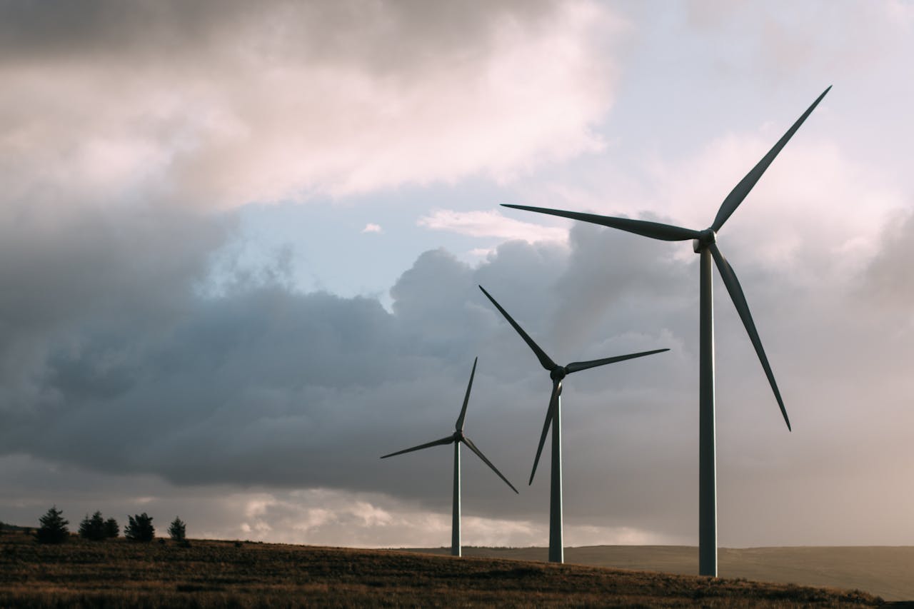 Wind turbines generating renewable energy under a dramatic cloudy sky.